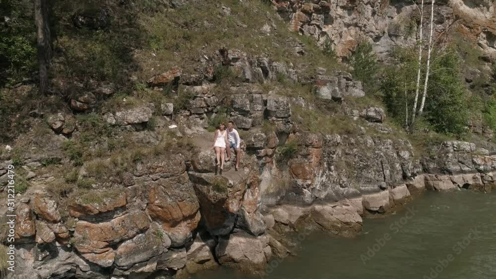 a guy and a girl are standing at the cliff a guy and a girl are standing at the cliff