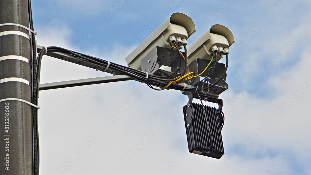 Obraz premium Twin highway road speed control camera close up back view on a mast in Moscow on blue sky background