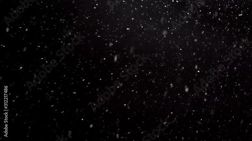 It is snowing in cold winter, Real snow falls on black background photo