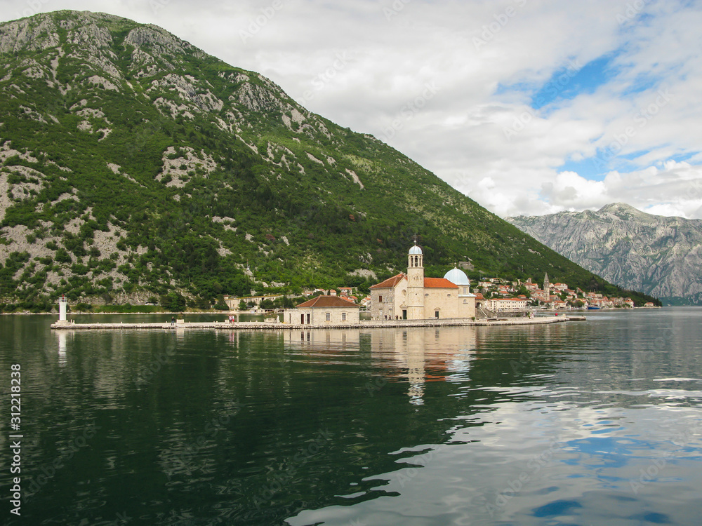 panoramic view from the ship to Perast, Gospa od Skrpjela, Kotor bay and the surrounding mountains, blue sky with white clouds, Montenegro