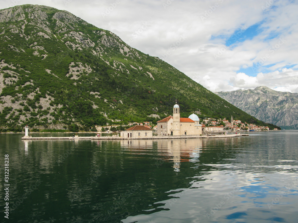 panoramic view from the ship to Perast, Gospa od Skrpjela, Kotor bay and the surrounding mountains, blue sky with white clouds, Montenegro panoramic view from the ship to Perast, Gospa od Skrpjela, Kotor bay and the surrounding mountains, blue sky with white clouds, Montenegro