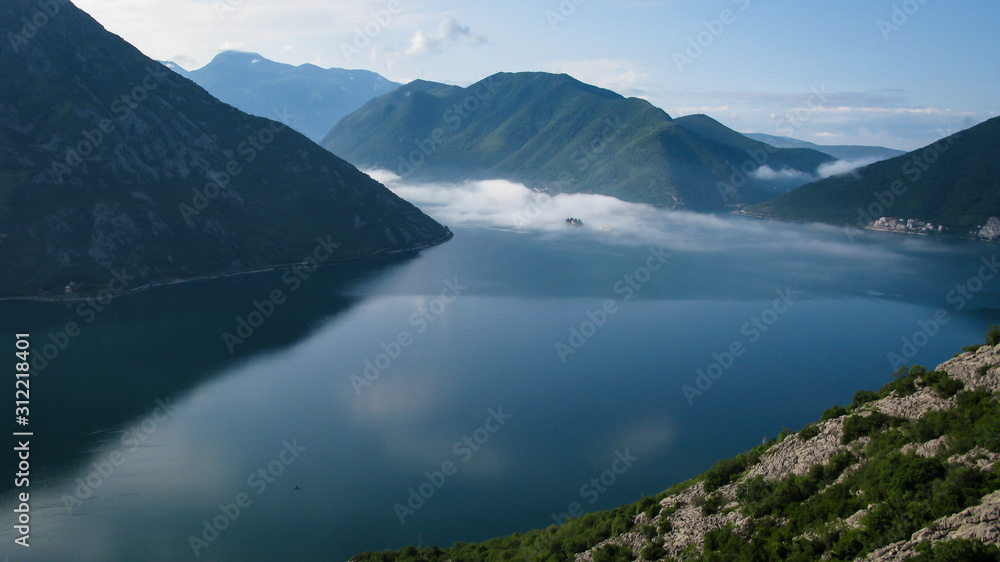 islands in fog in a Kotor bay near the city of Perast at sunrise, Montenegro
