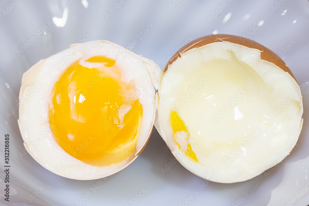 A close up shot of boiled egg in half in a white plate A close up shot of boiled egg in half in a white plate