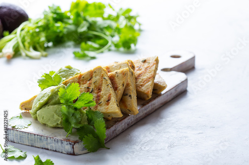 Grilled herbed tofu with avocado cream,  vegan meal, plant based diet photo