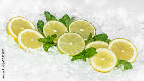 Lemon, Green Lemon and mint with crushed ice / ices cubes. Lemon ring. Ice background. Healty 2020.
