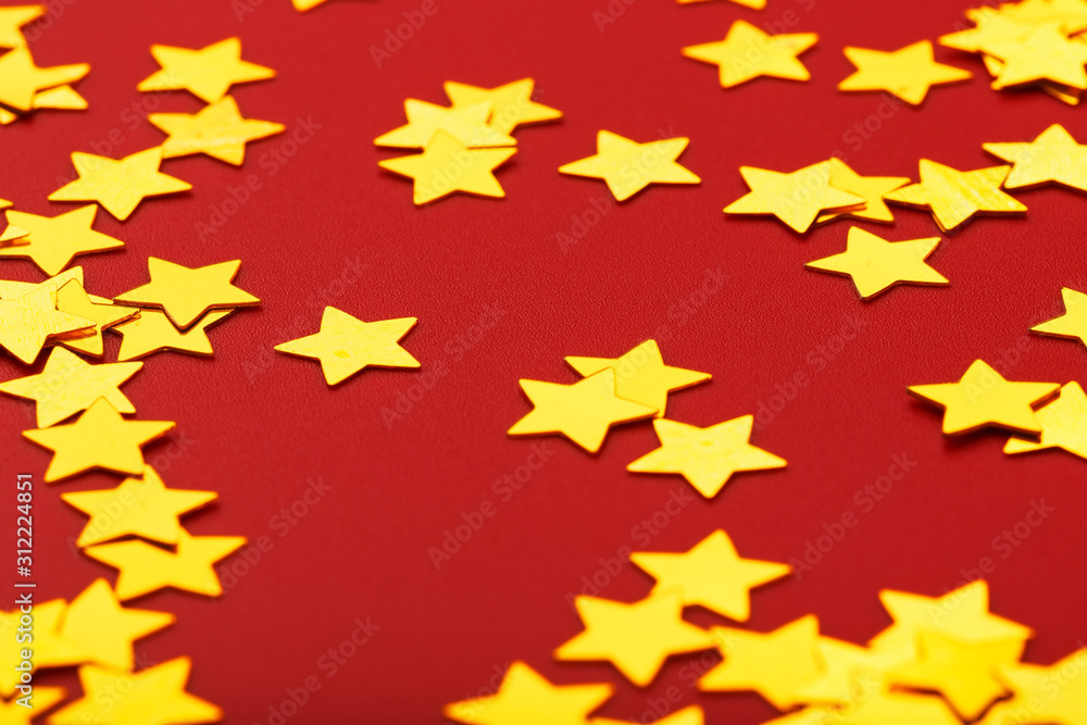 Gold stars on red background. The concept of greeting cards, headlines and web site. A scattering of Golden stars Gold stars on red background. The concept of greeting cards, headlines and web site. A scattering of Golden stars