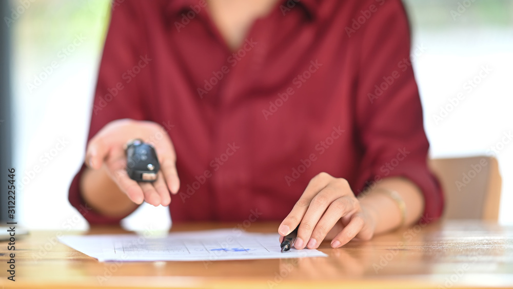 Young woman together with the car purchase agreement and keys. Young woman together with the car purchase agreement and keys.