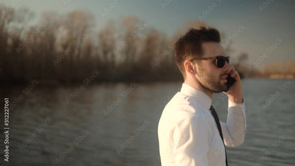 Businessman Talking On Smartphone Or Cell Phone.Man Talking On Mobile Phone.Handsome Successful Confident Businessman Talking On Phone.Attractive Businessman In Sunglasses Using Mobile Phone And Call Businessman Talking On Smartphone Or Cell Phone.Man Talking On Mobile Phone.Handsome Successful Confident Businessman Talking On Phone.Attractive Businessman In Sunglasses Using Mobile Phone And Call