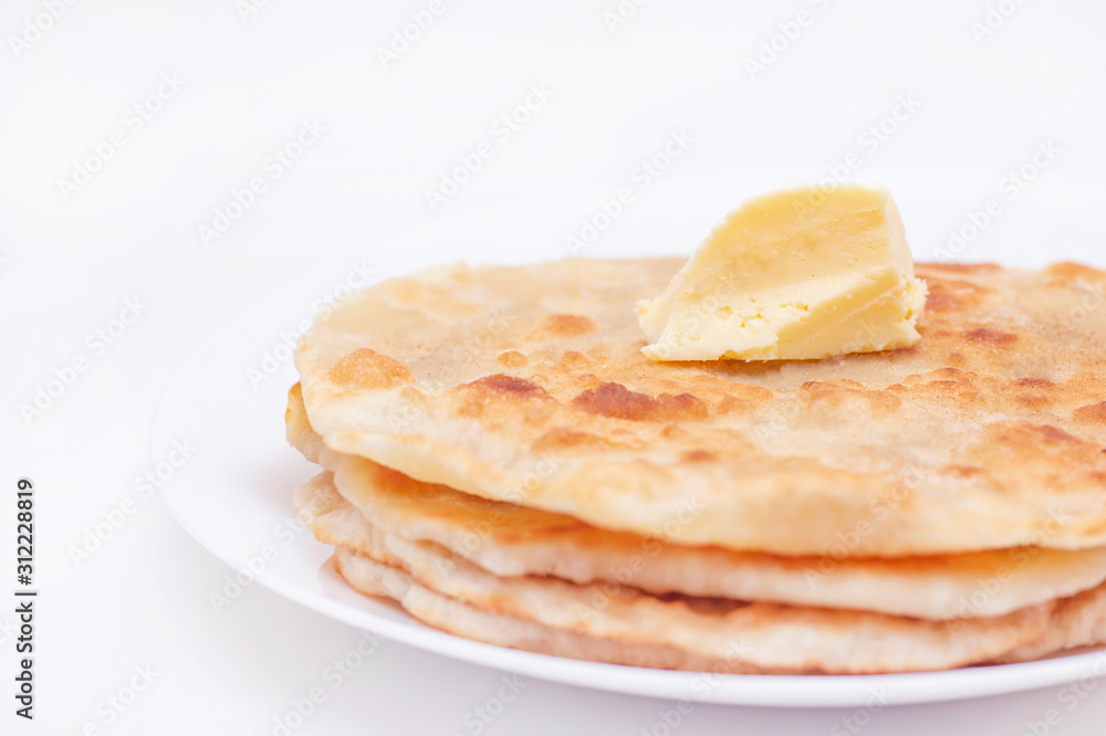 chapatti, tortilla, fried in oil in a pan. finished dish. a piece of butter lies on fried flat cakes. home cooking concept chapatti, tortilla, fried in oil in a pan. finished dish. a piece of butter lies on fried flat cakes. home cooking concept