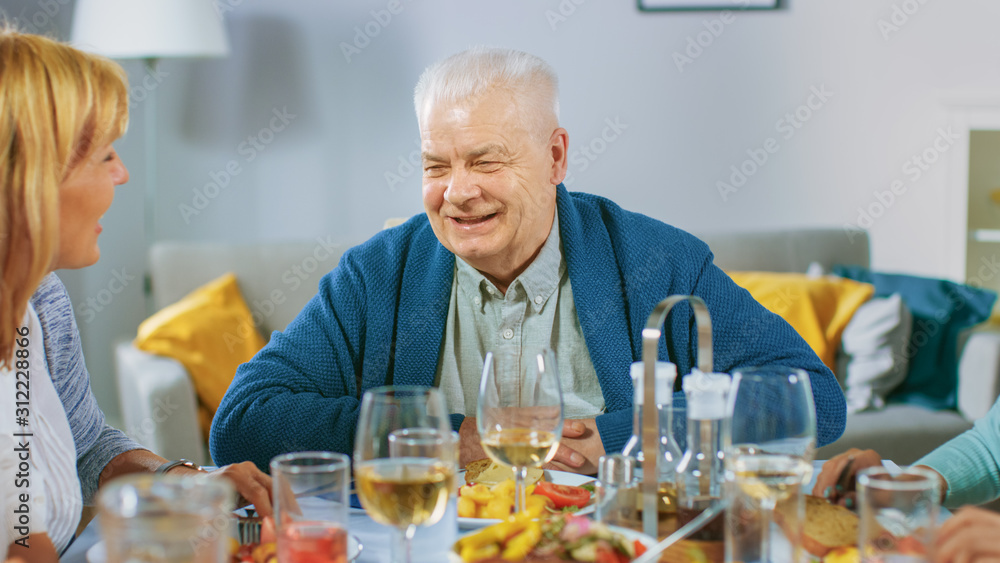 Big Family and Friends Celebration at Home, Diverse Group of Young Adults and Old People Gathered at the Table have Fun Conversation. Big Family and Friends Celebration at Home, Diverse Group of Young Adults and Old People Gathered at the Table have Fun Conversation.