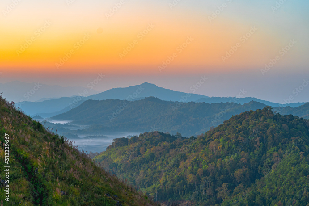 Obraz premium scenery sunrise above the mountain ridge on Doi Pha Phung at Nan province in Thailand.