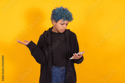 young afro american woman with mobile phone isolated on color background