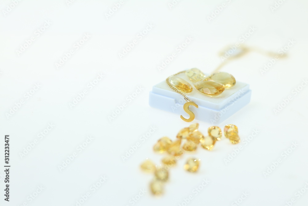 precious gift for your lover. Yellow sapphire gemstone jewellery and yellow loose stone on white background. Gems and Jewellery background precious gift for your lover. Yellow sapphire gemstone jewellery and yellow loose stone on white background. Gems and Jewellery background