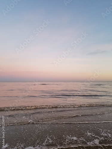 Winter day at the beach after sunset. View towards the ocean and the sky in pink and blue colors. Sæby, Denmark.