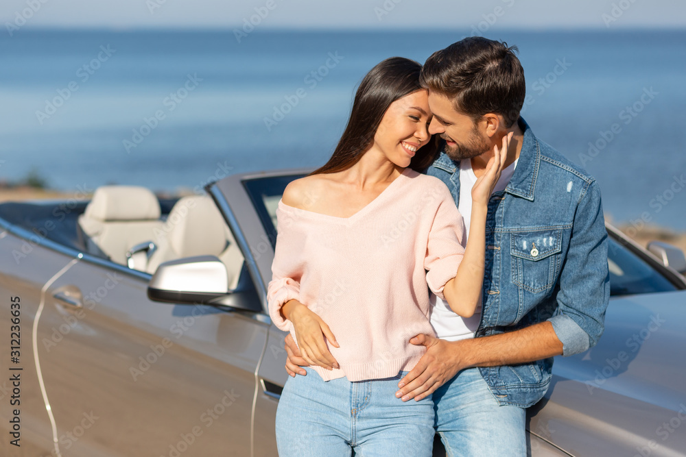 attractive woman and handsome man hugging together standing at the car