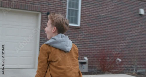 young boy scores a layup in driveway basketball