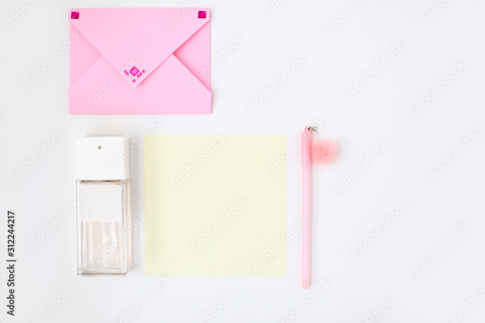 Flat lay: yellow paper, pink envelope, pen, pompom, perfume, lipstick, confetti hearts, lip print. Making postcard in envelope for Valentine's Day.Do it yourself.Photo from the series Flat lay: yellow paper, pink envelope, pen, pompom, perfume, lipstick, confetti hearts, lip print. Making postcard in envelope for Valentine's Day.Do it yourself.Photo from the series