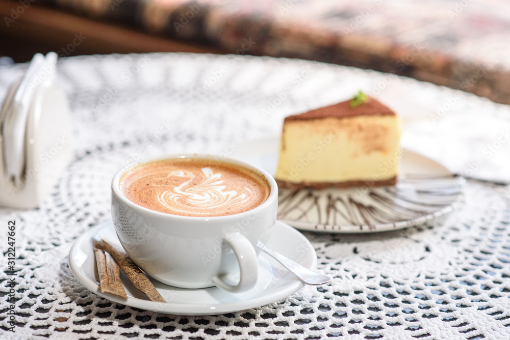 Coffee and Philadelphia cheesecake on a table in a cozy chocolate bar. Tasty and easy food. Coffee and Philadelphia cheesecake on a table in a cozy chocolate bar. Tasty and easy food.