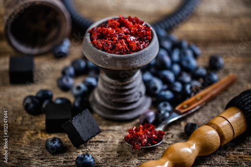 Stone hookah head on old rustic table with fruit flavoured tobacco