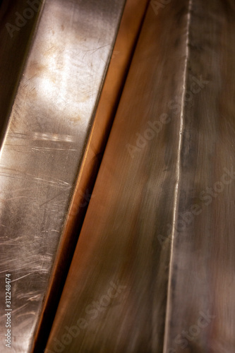 Curved copper sheet of various shapes. Glare on sheets of copper. Curved copper sheets close-up. Reflection on sheets of copper.