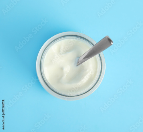 Tasty organic yogurt on light blue background, top view
