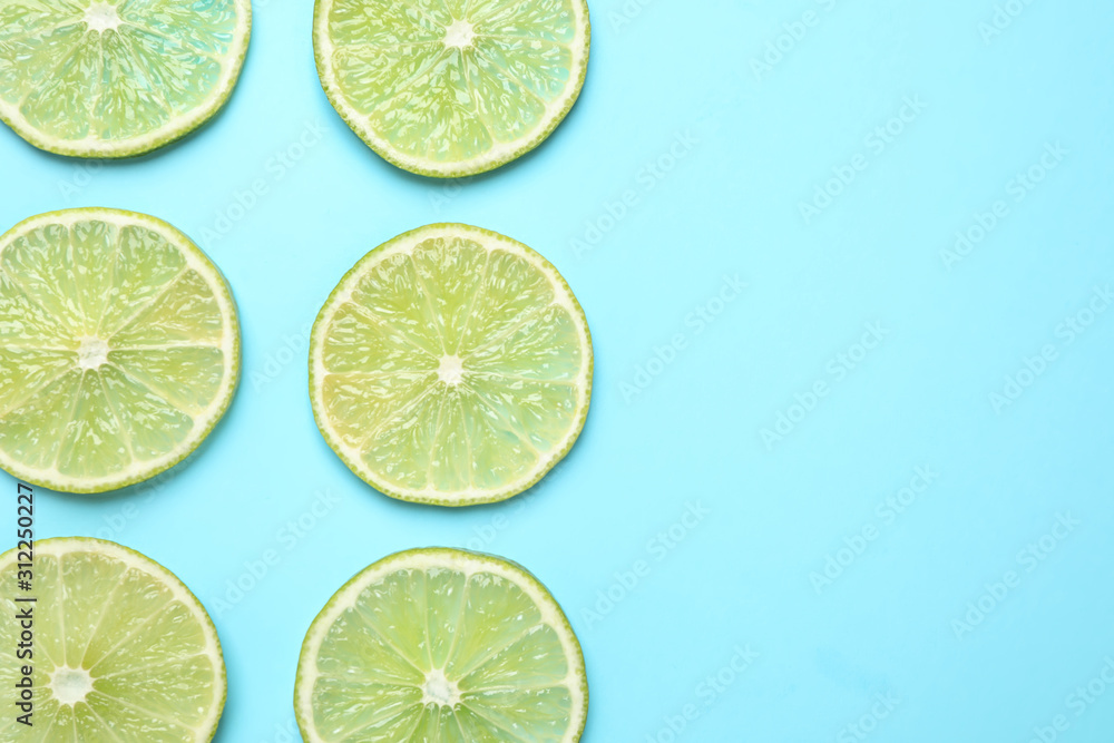 Fresh juicy lime slices on light blue background, flat lay. Space for text