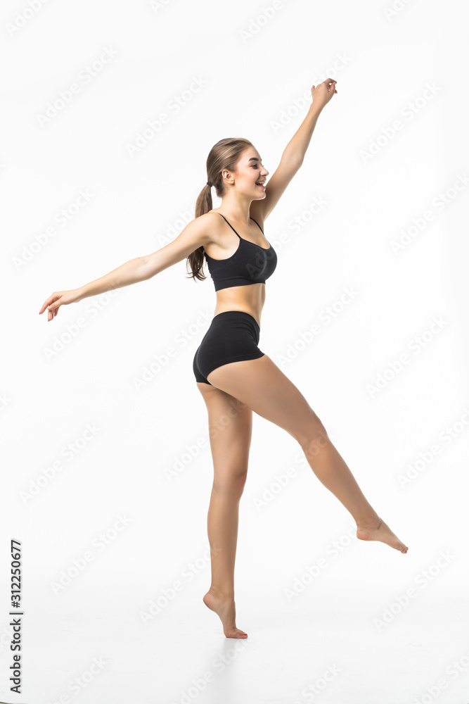 Full length portrait of a young brunette woman with perfect body raised hands in black sport lingerie posing and looking away isolated on a white background