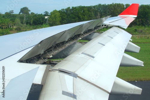 Jet plane air brakes and flaps fully extended after landing. Hydraulic actuators can be seen in the interior of the wing. photo