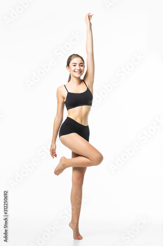 Full length portrait of a young brunette woman with perfect body raised hands in black sport lingerie posing and looking away isolated on a white background © F8  \ Suport Ukraine