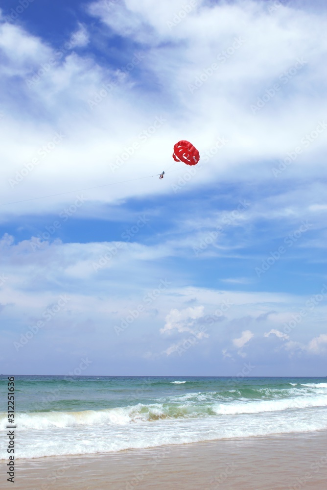 Parasailing on the beach of Phuket, Thailand, on a sunny day. Parasailing on the beach of Phuket, Thailand, on a sunny day.