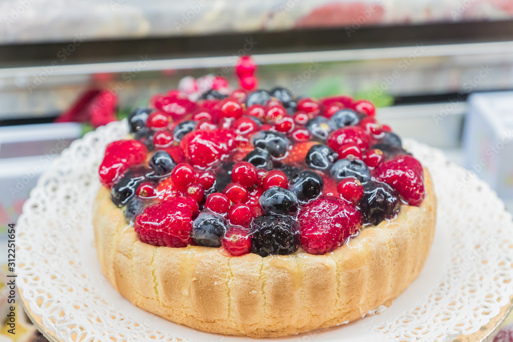 Freshly cooked cheese cake with berries at pastry window shop Freshly cooked cheese cake with berries at pastry window shop