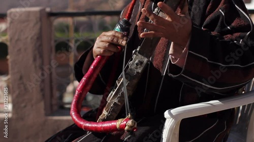 Closeup of berber musicians fingers playing the rabab in Taffraoute, Morocco. photo