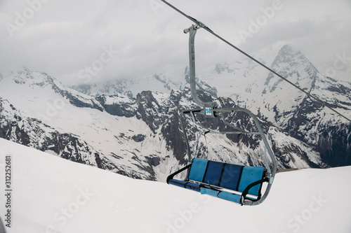 ski chair lift ropeway at the ski resort, view from the funicular to the mountains