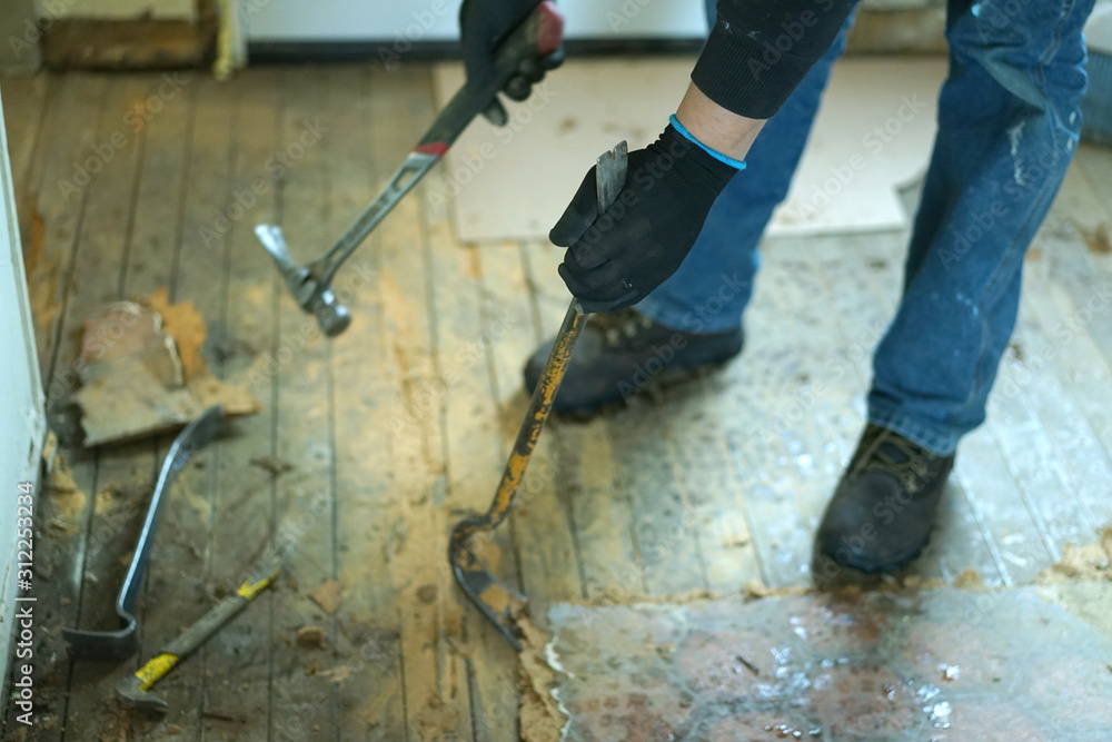 A man working with crowbar and a hammer. A man working with crowbar and a hammer.