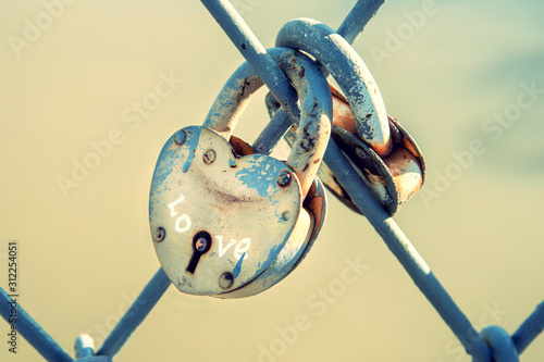 two heart-shaped padlocks hanging on iron bars. concept of marriage and traditions wedding