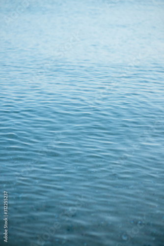 Blue ripple water wave on sand in sea ocean for background