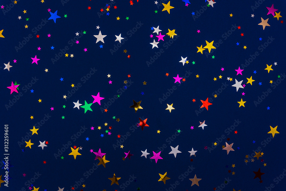 Classic blue abstract background. Festive concept. Color of the year 2020 concept. Colorful confetti in shape of star sparkling on blue backdrop Classic blue abstract background. Festive concept. Color of the year 2020 concept. Colorful confetti in shape of star sparkling on blue backdrop