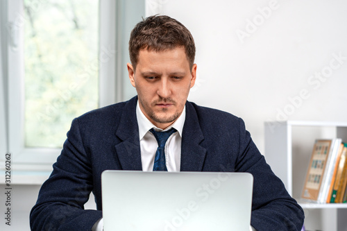 Shot of a young serious man working on laptop.