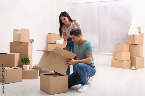 Happy couple unpacking cardboard boxes in their new flat on moving day © New Africa
