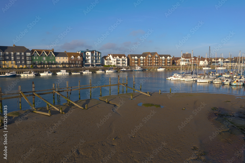 River Arun at Littlehampton at low tide with a view of boats and sailing boats moored on the East Bank and at the Yacht Club.