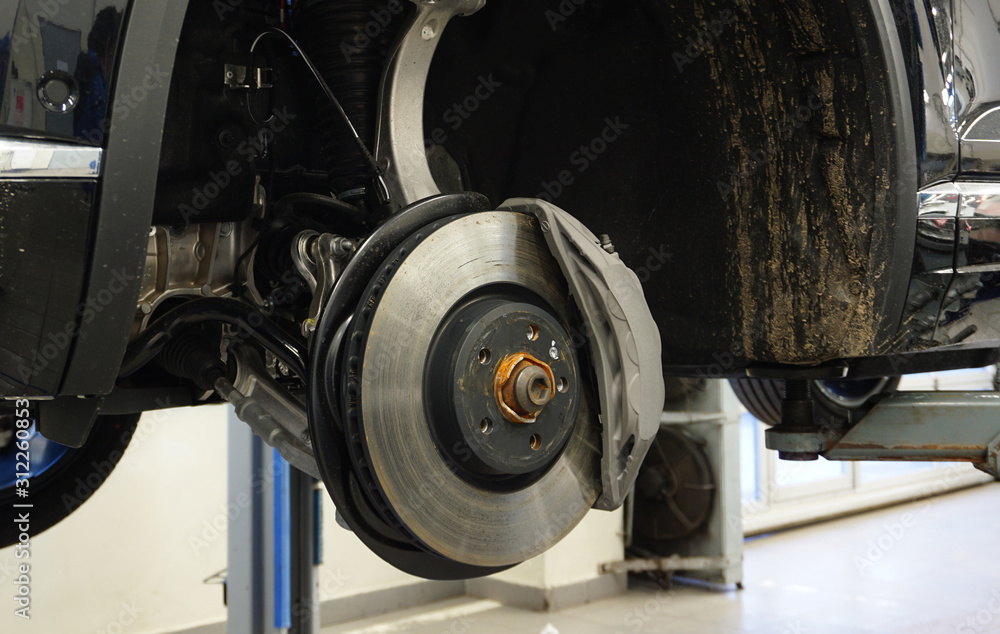 Brake disc and caliper of a modern car. Concept service and repair of a modern luxury car using original spare parts. Brake disc and caliper of a modern car. Concept service and repair of a modern luxury car using original spare parts.