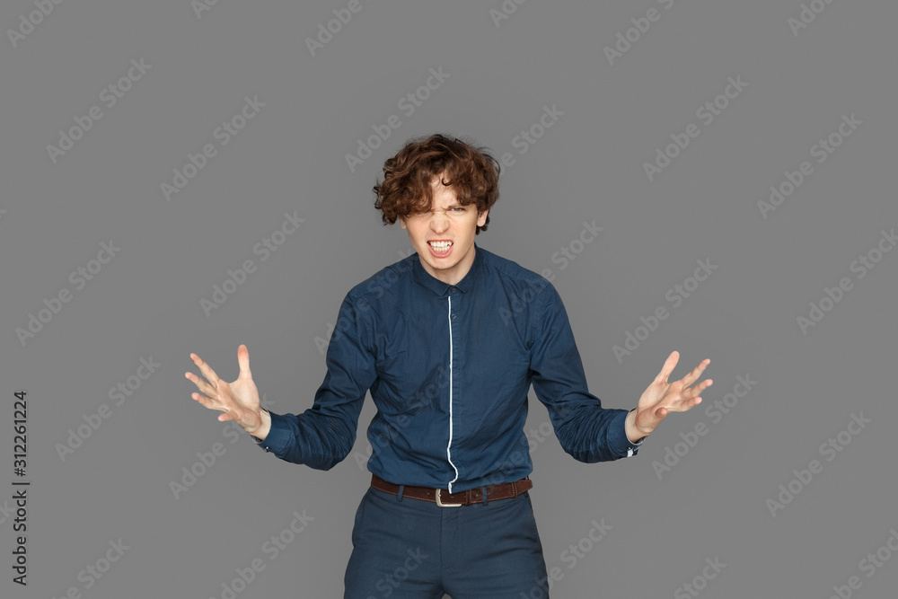 Freestyle. Teenager boy standing isolated on grey hands aside furious Freestyle. Teenager boy standing isolated on grey hands aside furious