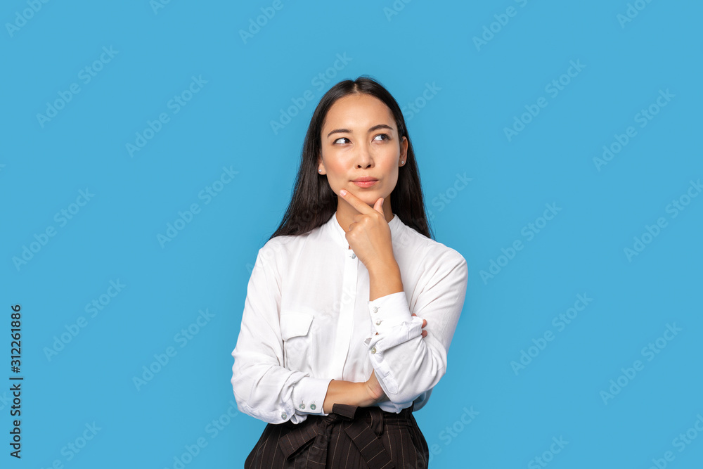 Freestyle. Young woman wearing shirt and skirt standing isolated on blue touching chin thinking of solution playful Freestyle. Young woman wearing shirt and skirt standing isolated on blue touching chin thinking of solution playful