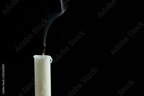An extinct candle with smoke on a black background. copy space for your text