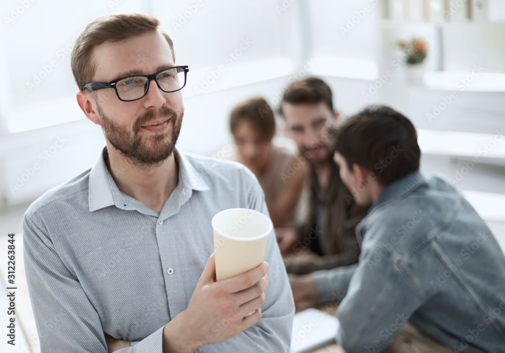 business man with a Cup of coffee standing in the office business man with a Cup of coffee standing in the office