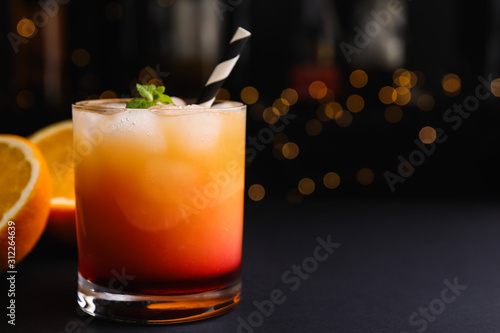Fresh alcoholic Tequila Sunrise cocktail on grey table. Space for text
