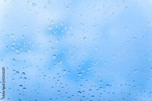 Raindrops on glass against blue sky