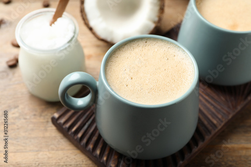 Delicious coffee with organic coconut oil on wooden table