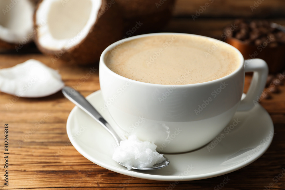 Delicious coffee with organic coconut oil on wooden table Delicious coffee with organic coconut oil on wooden table