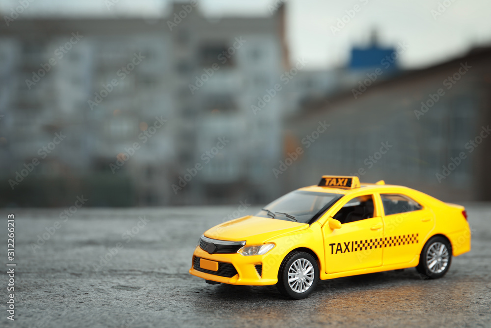 Yellow taxi car model on city street. Space for text Yellow taxi car model on city street. Space for text